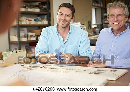 Three Architects Sitting Around Table Having Meeting View Large Photo Image Stock Image - Three Architects Sitting Around Table Having Meeting. Fotosearch