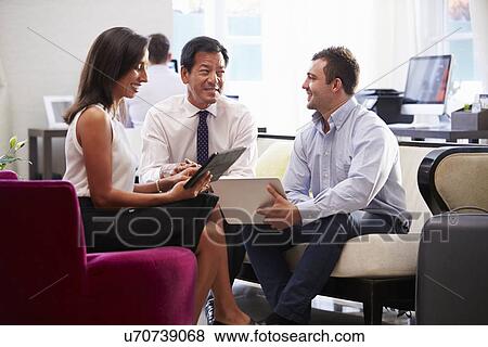 Three Businesspeople Having Meeting In Hotel Lobby View Large Photo Image Stock Photo - Three Businesspeople Having Meeting In Hotel Lobby. Fotosearch
