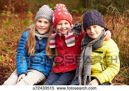 Stock Photography - Three Children On Walk Through Winter Woodland. Fotosearch