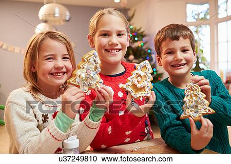 Stock Image - Three Children Showing Decorated Christmas Cookies . Fotosearch