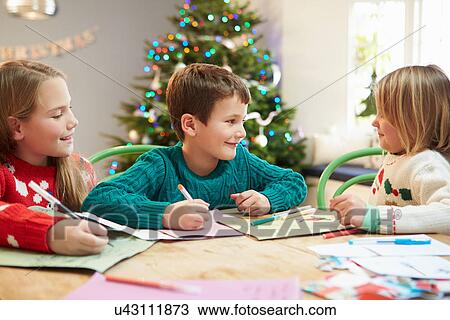 Stock Image - Three Children Writing Letters To Santa Together. Fotosearch
