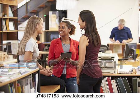 Three Female Architects Chatting In Modern Office Together View Large Photo Image Stock Image - Three Female Architects Chatting In Modern Office Together. Fotosearch