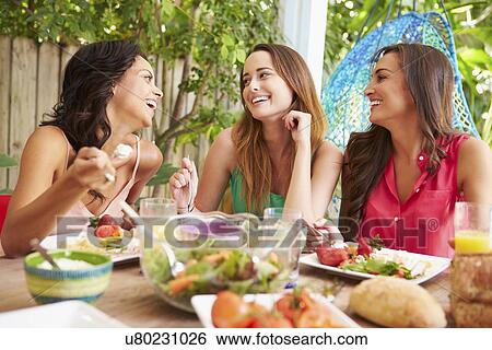 Three Female Friends Enjoying Meal Outdoors At Home View Large Photo Image Stock Photograph - Three Female Friends Enjoying Meal Outdoors At Home. Fotosearch