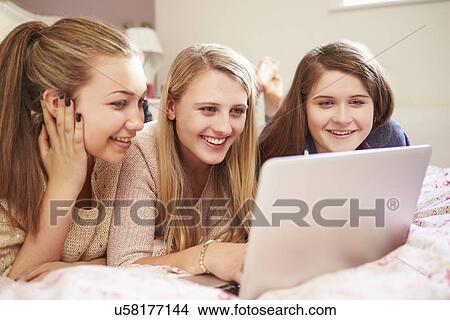 Three Teenage Girls Using Laptop In Bedroom View Large Photo Image Picture - Three Teenage Girls Using Laptop In Bedroom. Fotosearch