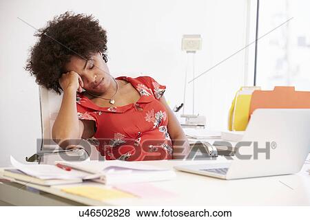Stock Photo - Tired Woman Working At Desk In Design Studio . Fotosearch
