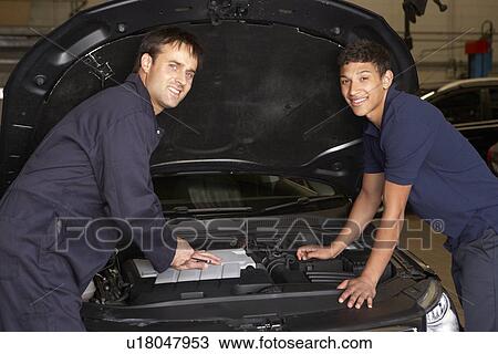 Stock Image - Trainee mechanic at work. Fotosearch