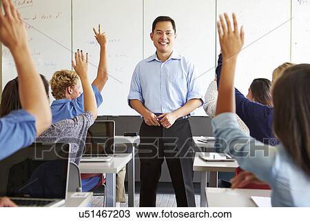 Stock Image - Tutor With High School Students In Class Using Laptops. Fotosearch