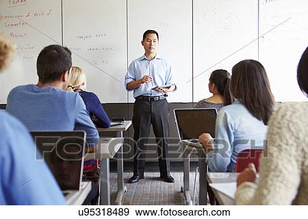 Stock Photo - Tutor With High School Students In Class Using Laptops. Fotosearch