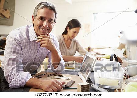 Stock Photo - Two Architects Making Models In Office Using Digital Tablet. Fotosearch