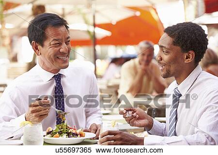 Stock Photography - Two Businessmen Having Meeting In Outdoor Restaurant. Fotosearch