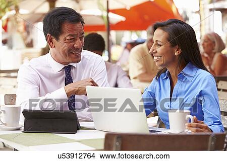 Picture - Two Businesspeople Having Meeting In Outdoor Cafe. Fotosearch