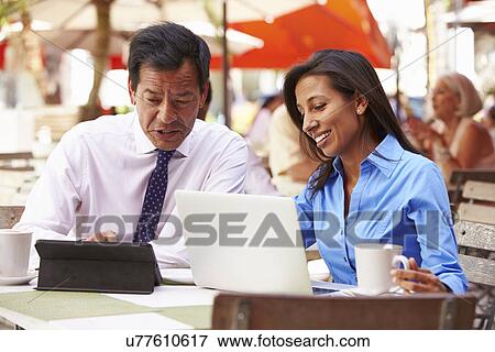 Two Businesspeople Having Meeting In Outdoor Cafe View Large Photo Image Stock Photo - Two Businesspeople Having Meeting In Outdoor Cafe. Fotosearch