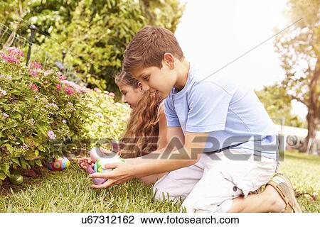 Two Children Having Easter Egg Hunt In Garden View Large Photo Image Stock Image - Two Children Having Easter Egg Hunt In Garden. Fotosearch