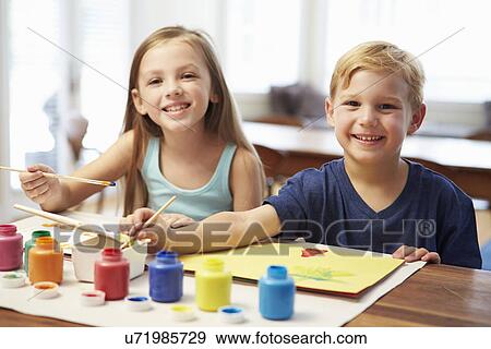 Stock Photo - Two Children Painting Picture At Home. Fotosearch