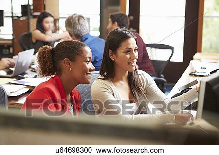Two Colleagues Working At Desk With Meeting In Background View Large Photo Image Stock Image - Two Colleagues Working At Desk With Meeting In Background. Fotosearch