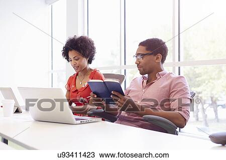 Stock Image - Two Creatives With Digital Tablet Working In Design Studio. Fotosearch