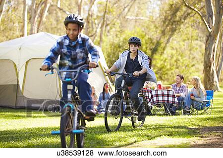 Stock Photo - Two Families Enjoying Camping Holiday In Countryside. Fotosearch