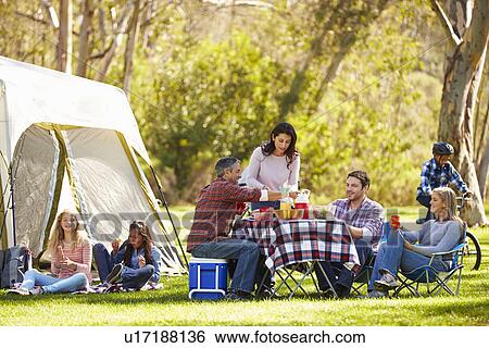 Stock Photograph - Two Families Enjoying Camping Holiday In Countryside. Fotosearch