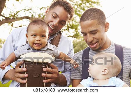Stock Image - Two Fathers With Baby Carriers Walking In Park. Fotosearch