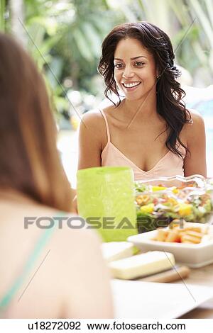 Two Female Friends Enjoying Meal Outdoors At Home View Large Photo Image Stock Image - Two Female Friends Enjoying Meal Outdoors At Home. Fotosearch