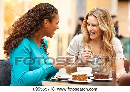 Two Female Friends Meeting In Cafe View Large Photo Image Stock Photo - Two Female Friends Meeting In Cafe. Fotosearch