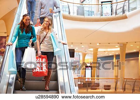 Two Female Friends On Escalator In Shopping Mall View Large Photo Image Stock Image - Two Female Friends On Escalator In Shopping Mall. Fotosearch