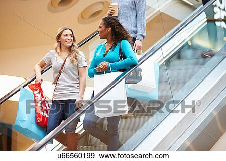 Two Female Friends On Escalator In Shopping Mall View Large Photo Image Stock Photo - Two Female Friends On Escalator In Shopping Mall. Fotosearch