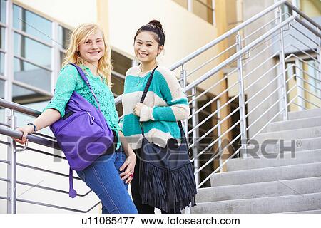 Stock Photo - Two Female High School Students Standing Outside Building. Fotosearch