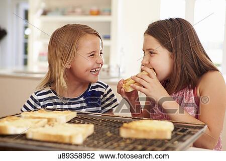 Two Girls Eating Cheese On Toast In Kitchen View Large Photo Image Stock Image - Two Girls Eating Cheese On Toast In Kitchen. Fotosearch
