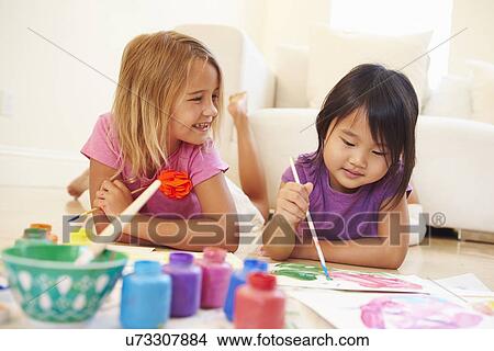 Two Girls Lying On Floor And Painting Picture At Home View Large Photo Image Picture - Two Girls Lying On Floor And Painting Picture At Home. Fotosearch