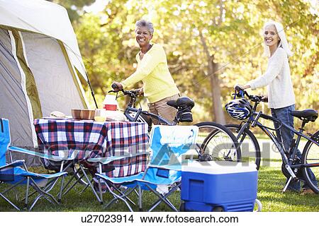 Two Mature Women Riding Bikes On Camping Holiday View Large Photo Image Picture - Two Mature Women Riding Bikes On Camping Holiday. Fotosearch