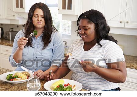 Two Overweight Women On Diet Eating Healthy Meal In Kitchen View Large Photo Image Stock Image - Two Overweight Women On Diet Eating Healthy Meal In Kitchen. Fotosearch