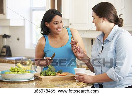 Stock Photography - Two Overweight Women On Diet Preparing Vegetables in Kitchen. Fotosearch