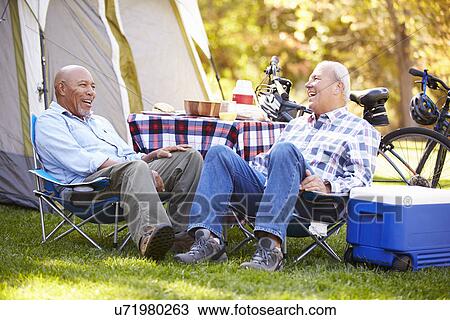 Stock Image - Two Senior Men Relaxing On Camping Holiday. Fotosearch