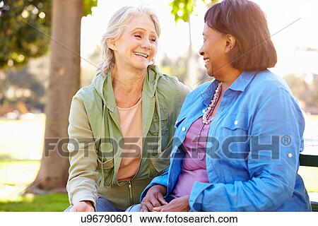 Stock Image - Two Senior Women Talking Outdoors Together. Fotosearch