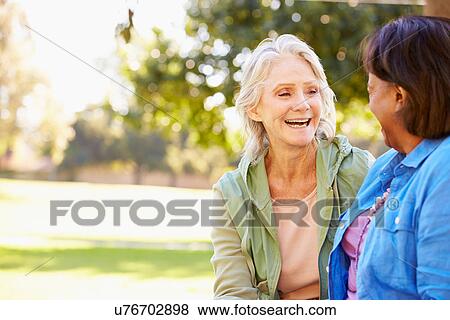 Two Senior Women Talking Outdoors Together View Large Photo Image Stock Photo - Two Senior Women Talking Outdoors Together. Fotosearch