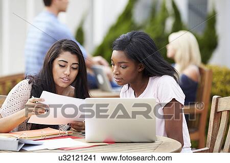 Stock Image - Two University Students Working On Project Outdoors Together. Fotosearch