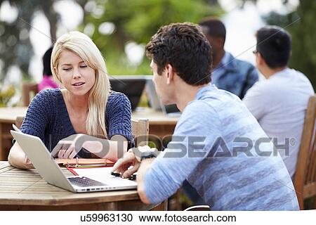 Stock Image - Two University Students Working On Project Outdoors Together. Fotosearch
