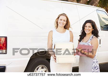 Stock Photo - Two Women Running Catering Business With Van. Fotosearch