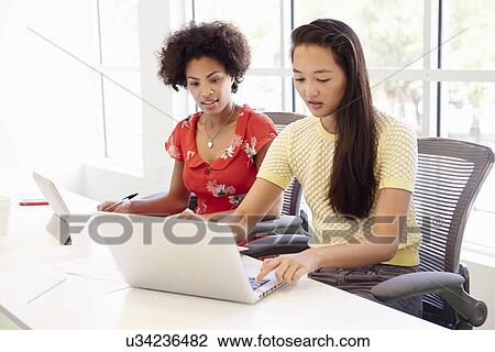 Two Women Working Together In Design Studio View Large Photo Image Stock Image - Two Women Working Together In Design Studio. Fotosearch