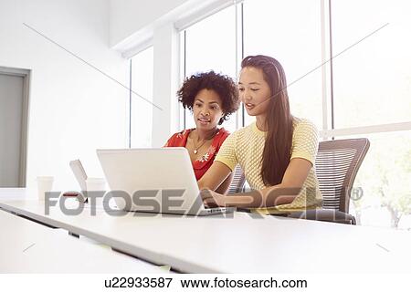 Stock Photo - Two Women Working Together In Design Studio. Fotosearch