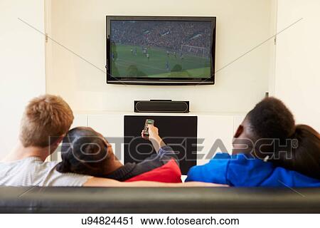 Stock Image - Two Young Couples Watching Television At Home Together. Fotosearch