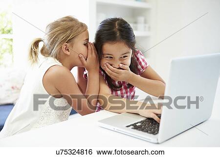 Two Young Girls Using Laptop At Home And Whispering View Large Photo Image Stock Photograph - Two Young Girls Using Laptop At Home And Whispering. Fotosearch