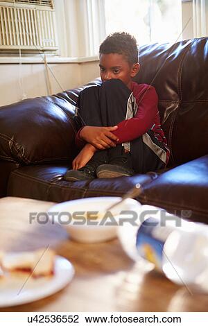 Unhappy Boy Sitting On Sofa At Home View Large Photo Image Stock Image - Unhappy Boy Sitting On Sofa At Home. Fotosearch