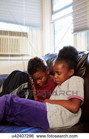Unhappy Children Sitting On Sofa At Home View Large Photo Image Stock Photograph - Unhappy Children Sitting On Sofa At Home. Fotosearch