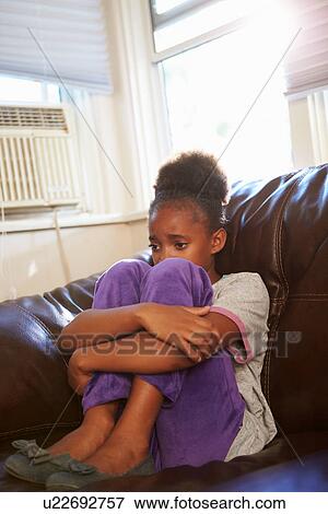 Unhappy Girl Sitting On Sofa At Home View Large Photo Image Stock Photo - Unhappy Girl Sitting On Sofa At Home. Fotosearch