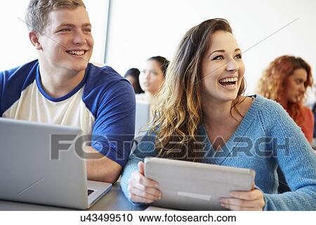 Stock Image - University Students Using Digital Tablet And Laptop In Class. Fotosearch