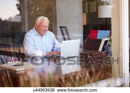 View Of Senior Man Using Laptop Through Window View Large Photo Image Stock Photo - View Of Senior Man Using Laptop Through Window. Fotosearch