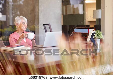 View Of Senior Woman Using Laptop Through Window View Large Photo Image Stock Photo - View Of Senior Woman Using Laptop Through Window. Fotosearch