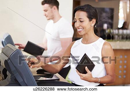 Stock Photo - Waiter And Waitress In Hotel Restaurant Preparing Bill. Fotosearch